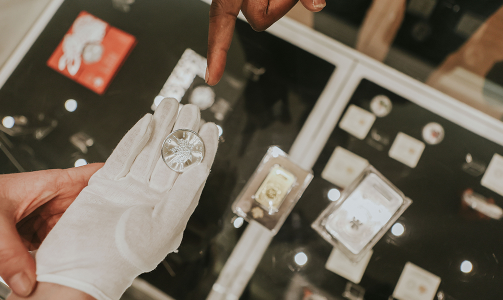 Close up of a silver coin in gloved hand.