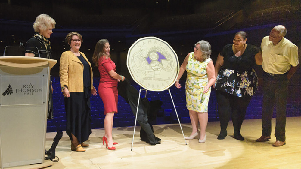 Photo of a coin reveal with people on stage.