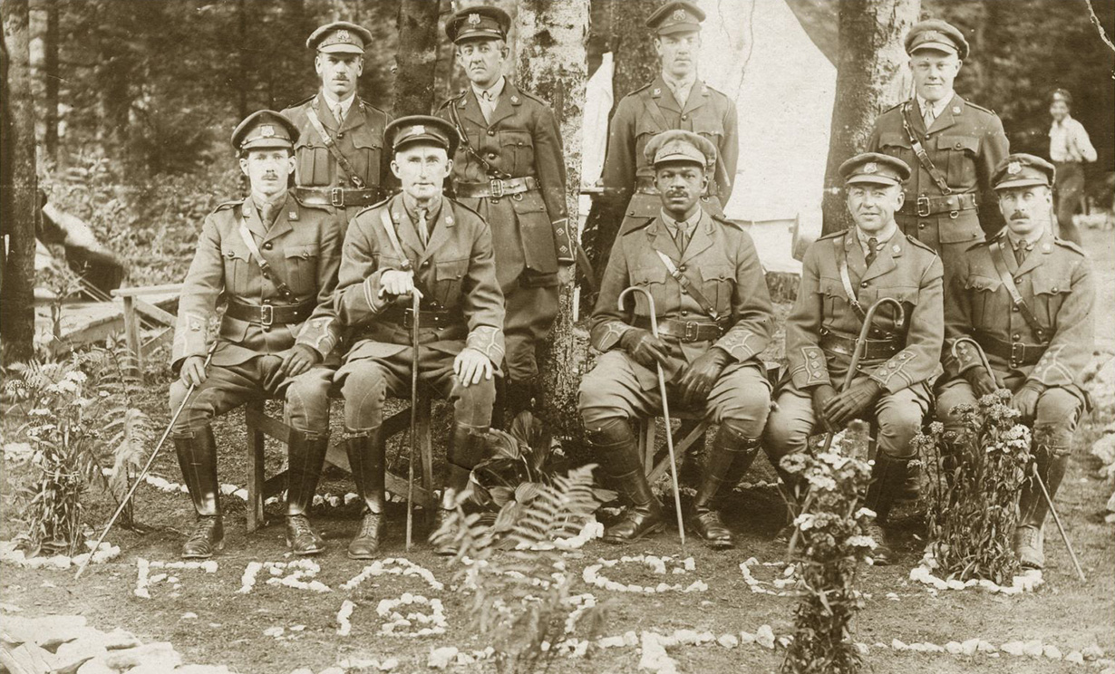Nine uniformed No. 2 Construction Battalion officers, Rev. Dr. W. Andrew White seated in the middle